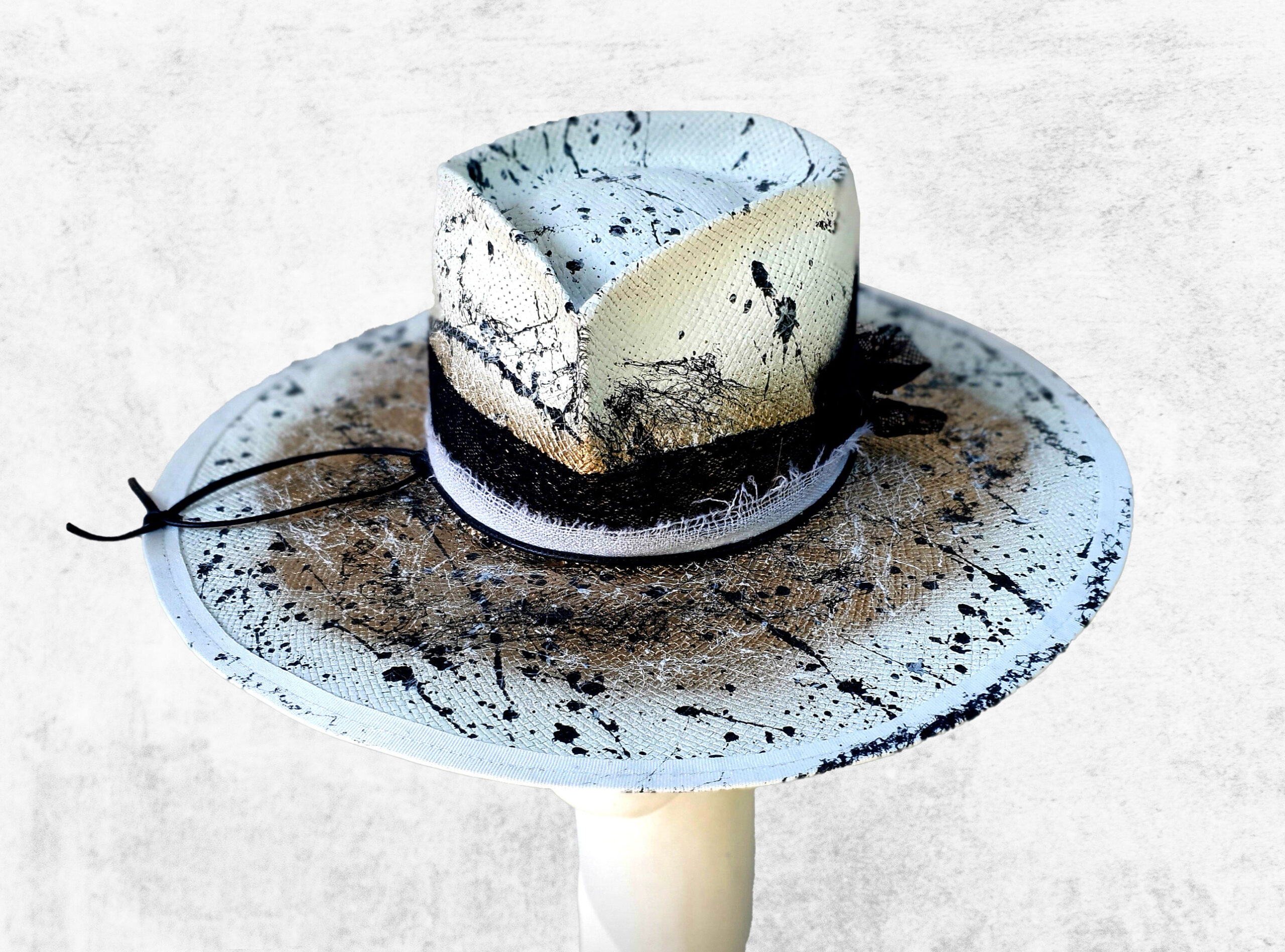 White Gold hat with black feather details. Handpainted cellulose- special paper hat with leather
