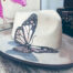 white hat with handmade butterfly painted with metalic colours