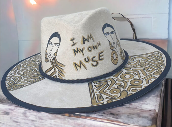 Custom white hat with message I am my own muse, with girls painted o the crown and minimalist abstract details on the brim